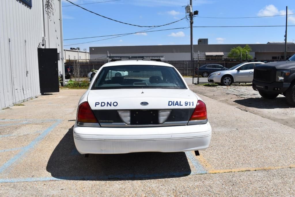 A white ford police car is parked in a parking lot
