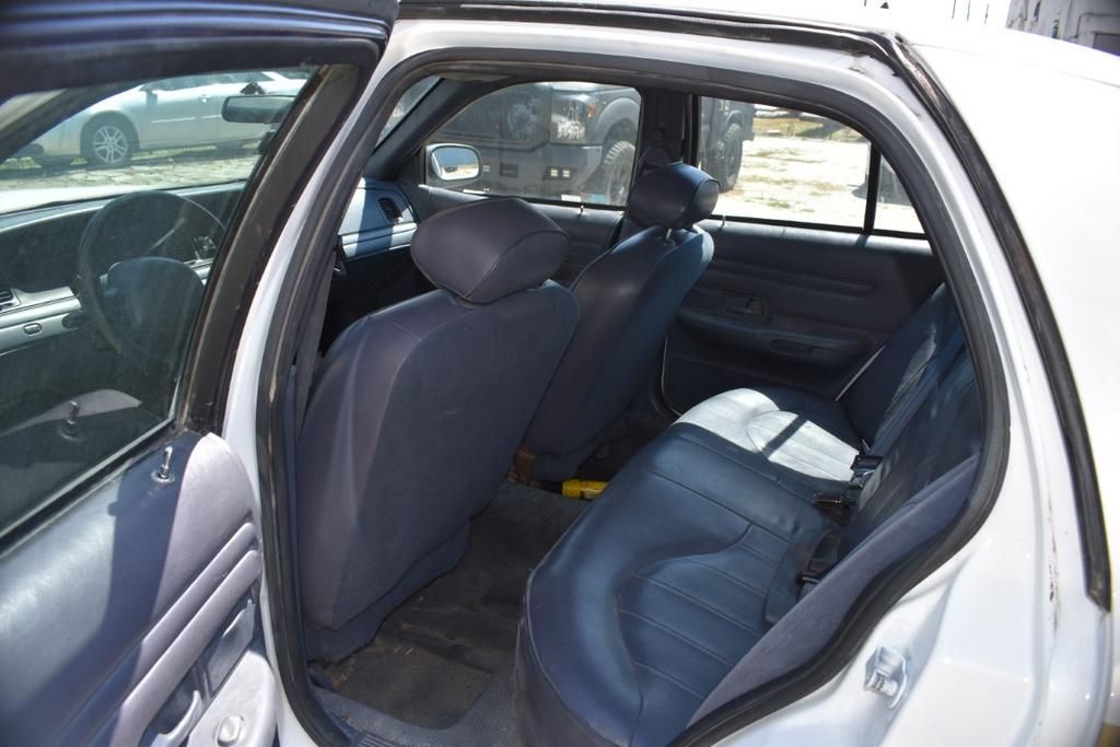 The back seat of a white car with the door open