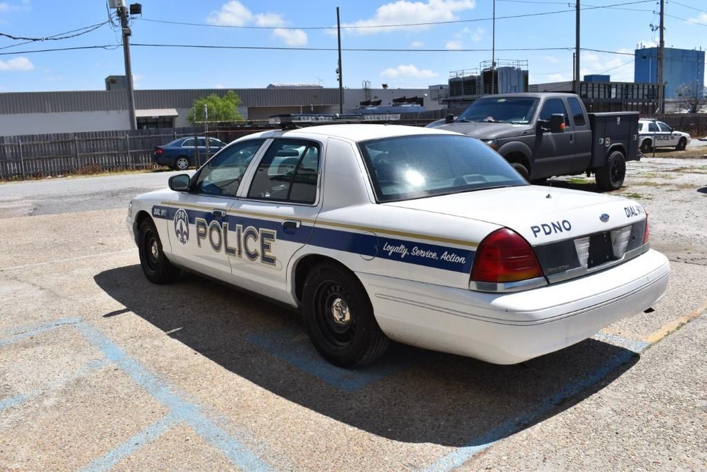 A white police car is parked in a parking lot