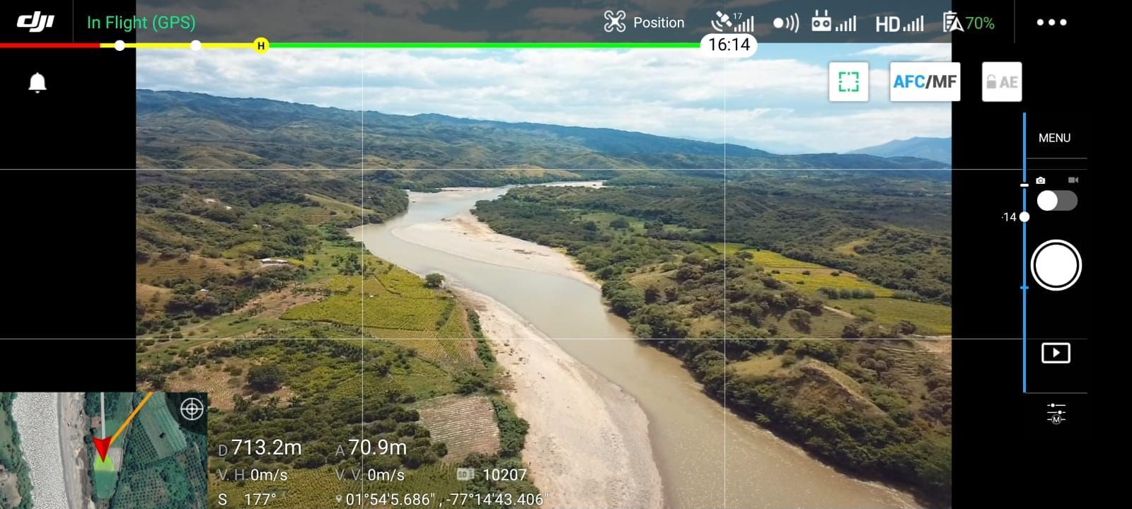 Vista aérea de un río que fluye a través de un exuberante paisaje verde, tomada desde un dron