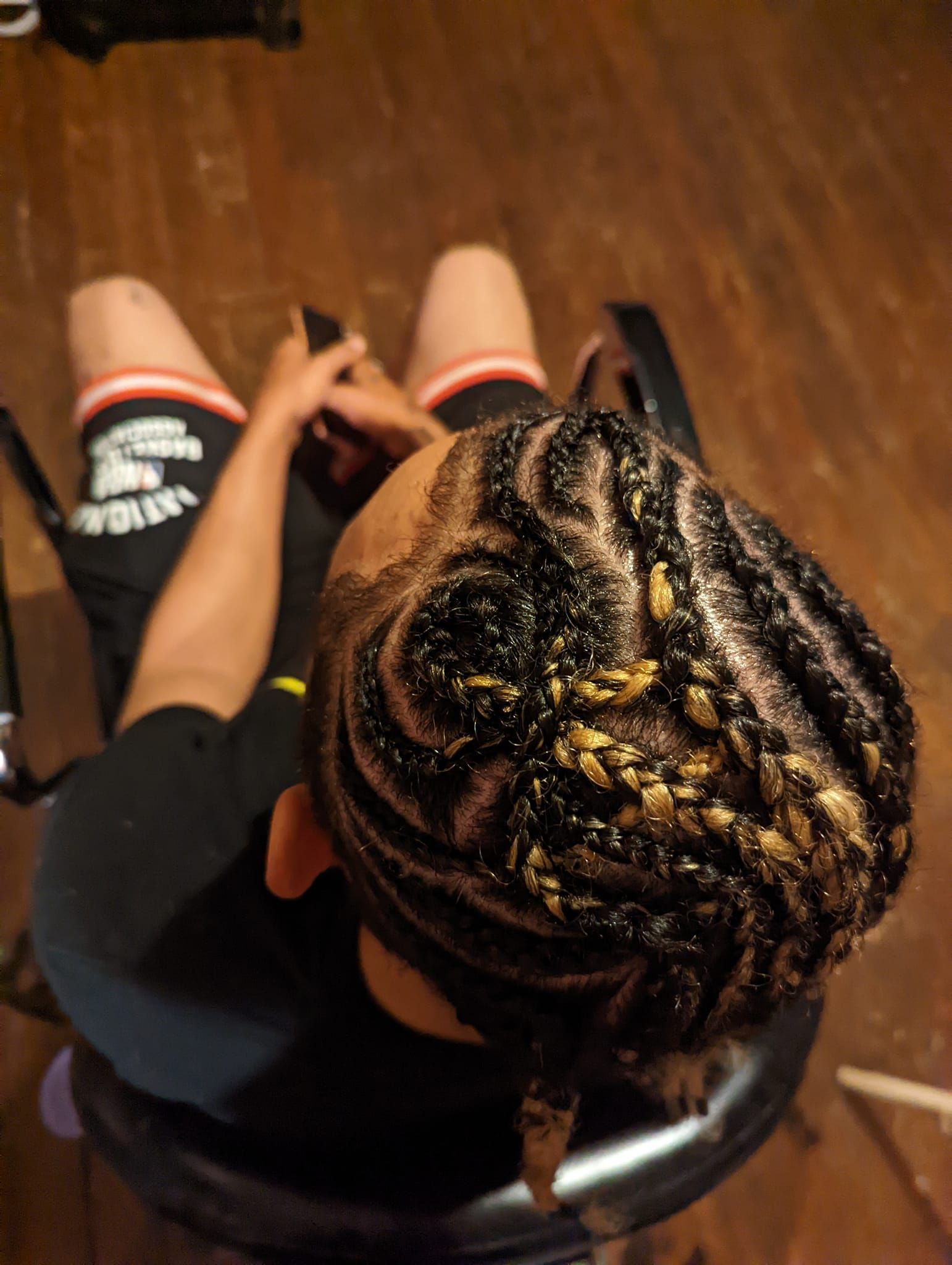 A person is sitting in a chair with braids in their hair.