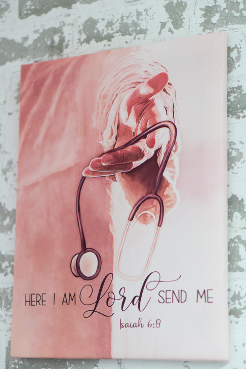 Medical team in scrubs and lab coats smiling, arms crossed, in a brightly lit hallway.