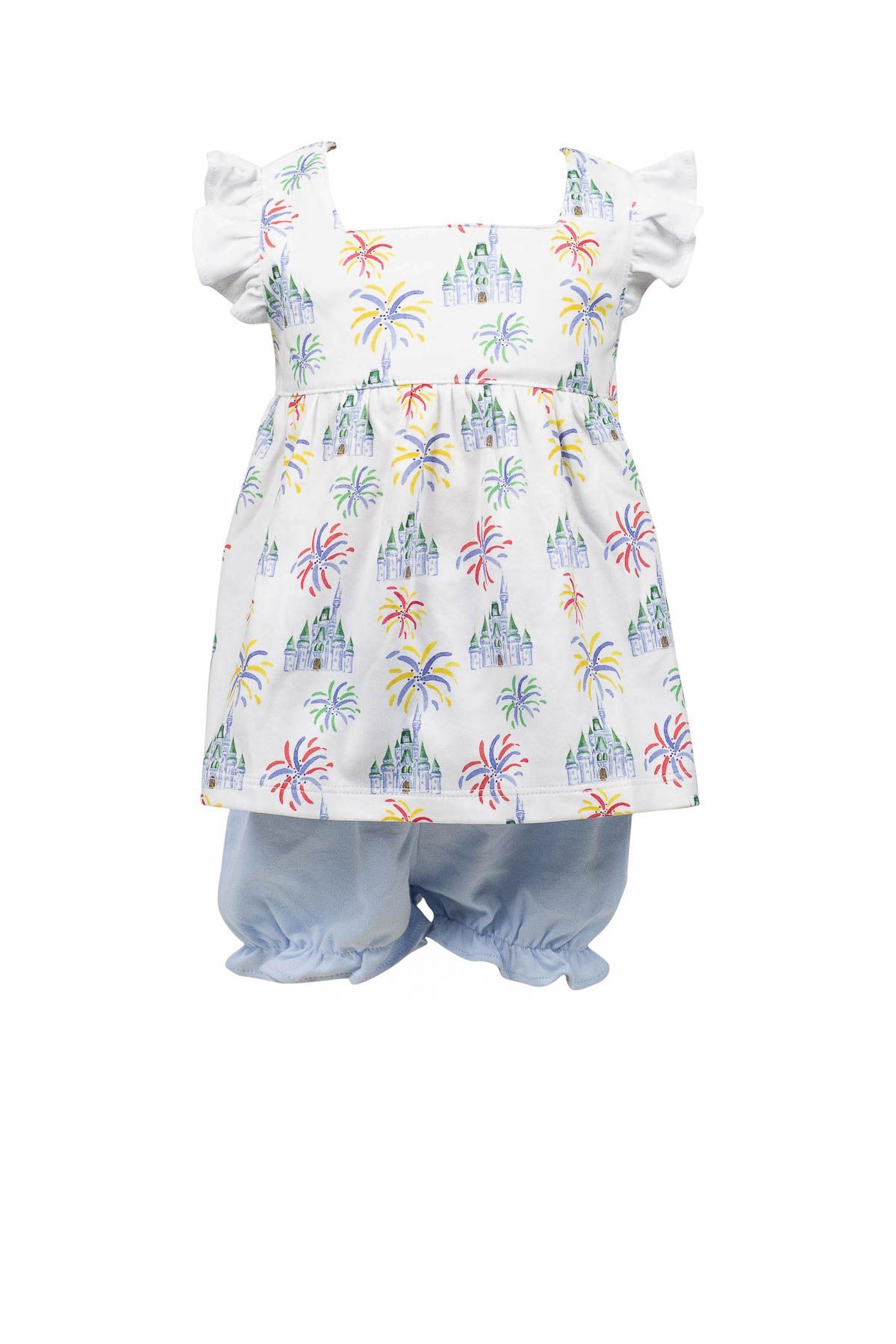 A baby girl is wearing a white dress and blue shorts.