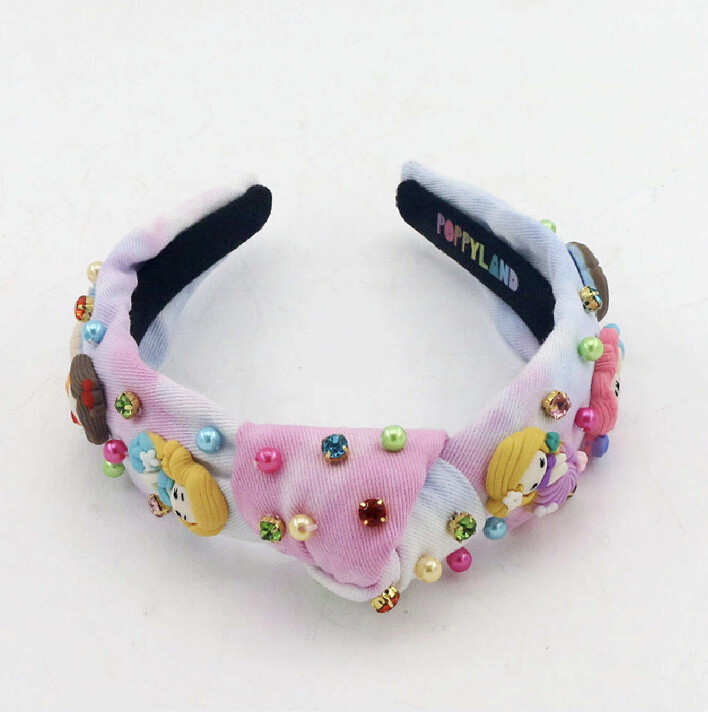 A pink and white headband with candy on it