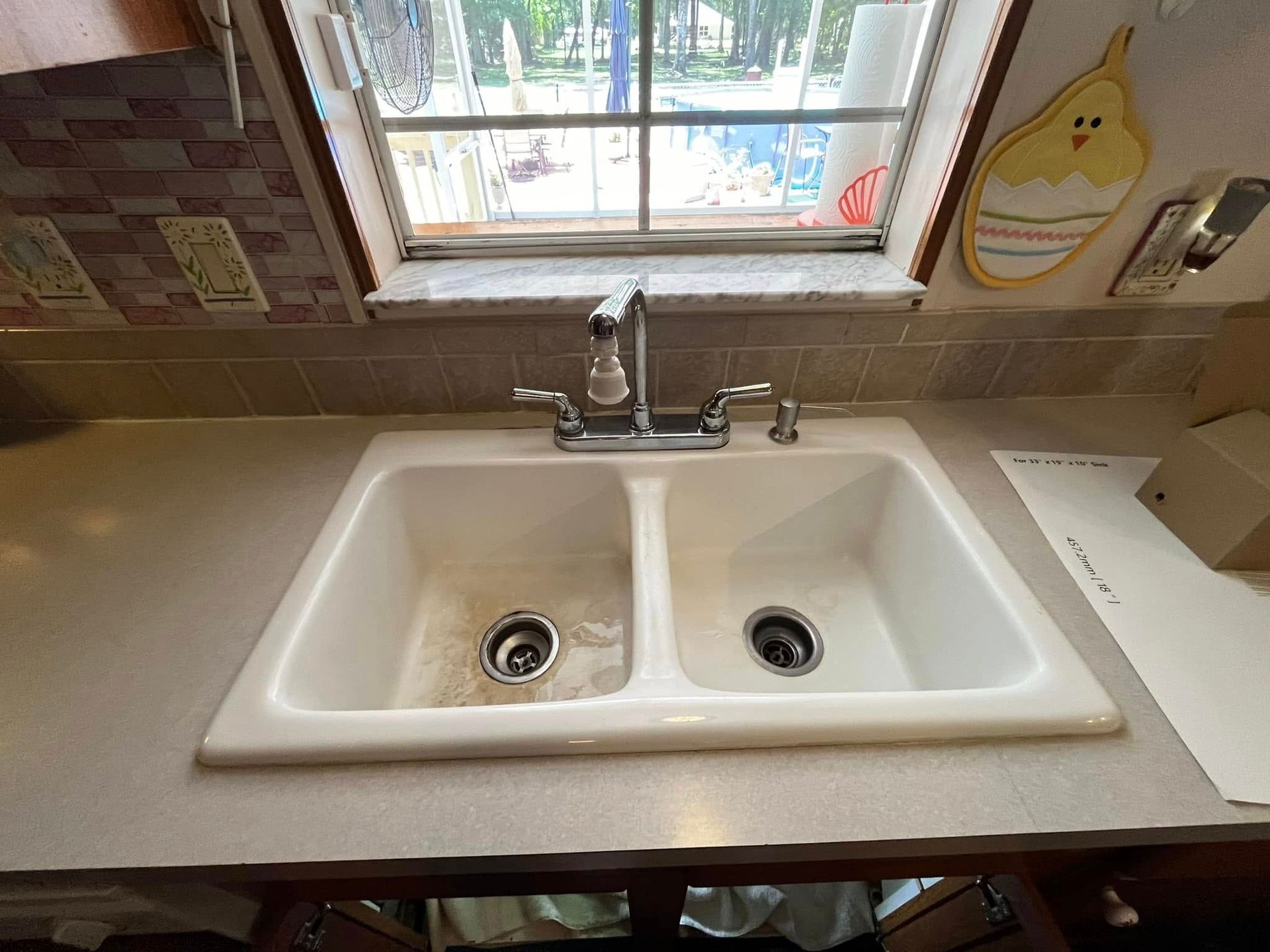 A kitchen sink with a window in the background