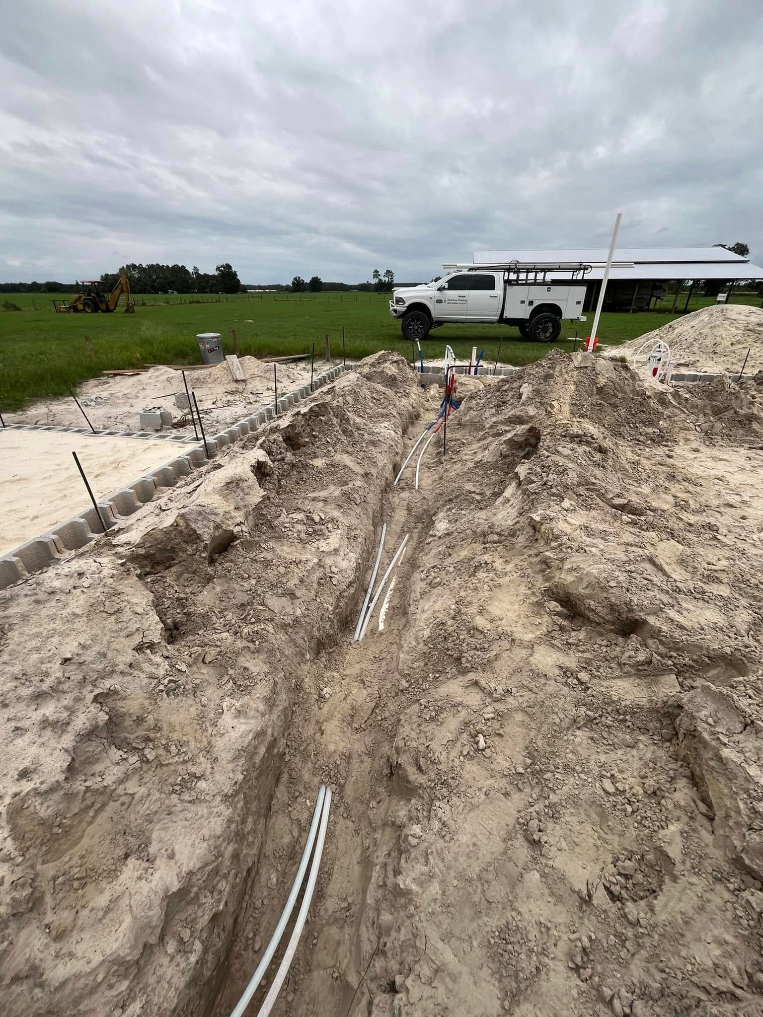 A white truck is parked on the side of a dirt road.