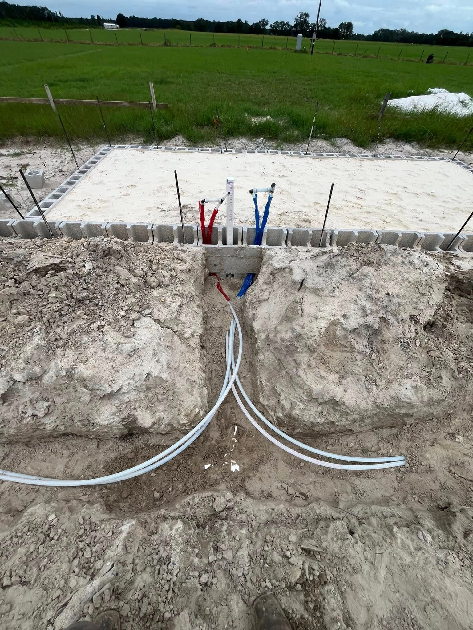 A bunch of wires are laying in the dirt in a field.