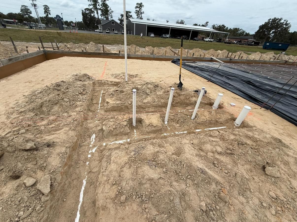 A construction site with a lot of dirt and pipes in it.