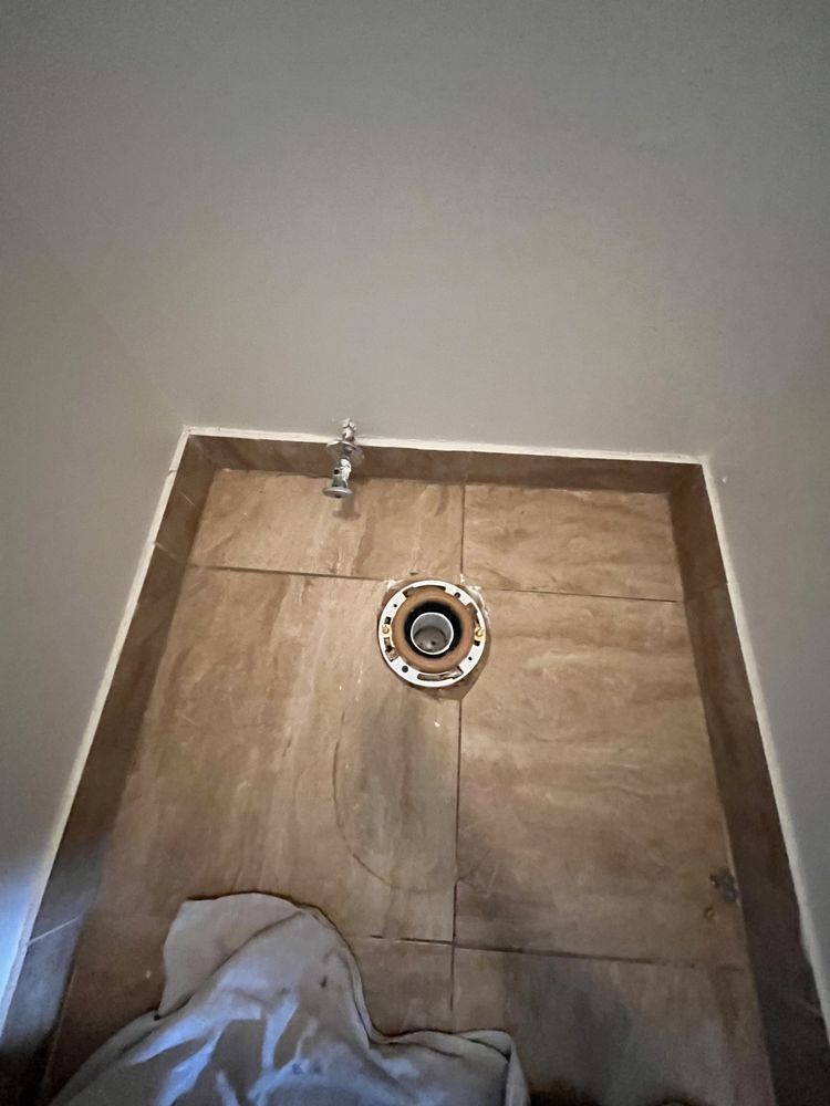 There is a hole in the floor of a bathroom.