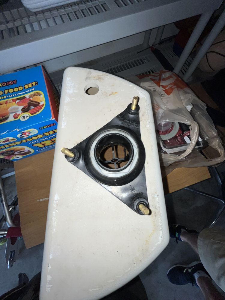 A toilet bowl is sitting on a table next to a box that says food safe