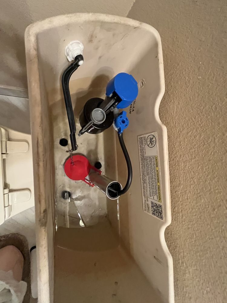 A close up of a toilet tank with water coming out of it.