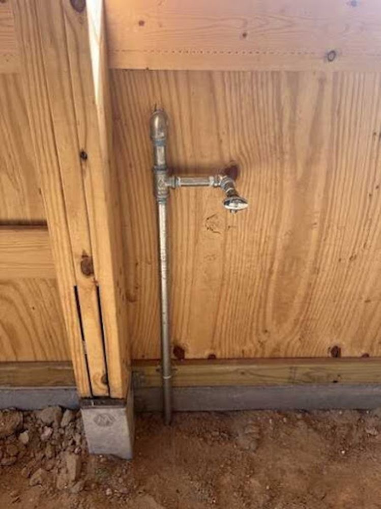 A water faucet is attached to a wooden wall.