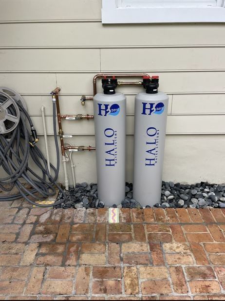 Two halo water filters are sitting on the side of a house.