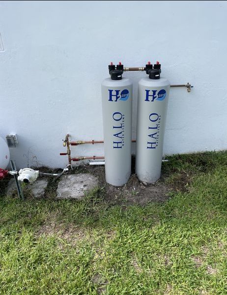 Two halo water filters are sitting next to each other in the grass.