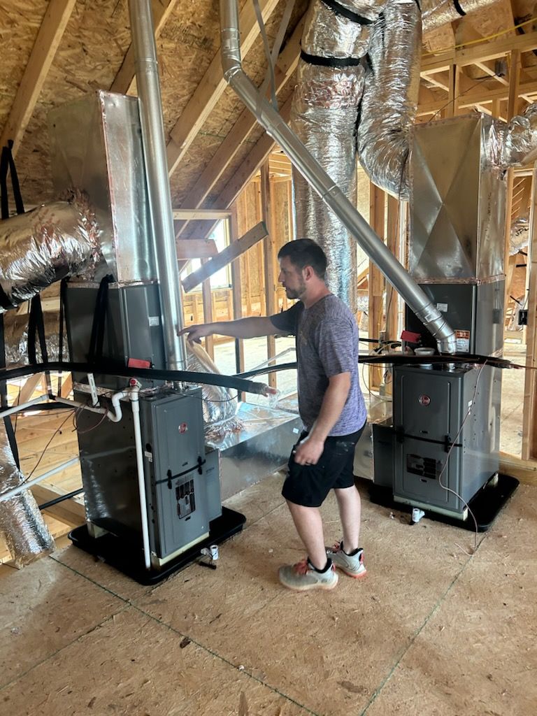 A man is working on a ceiling mounted air conditioner.