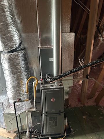 A man is carrying a bag of tools and a hose.