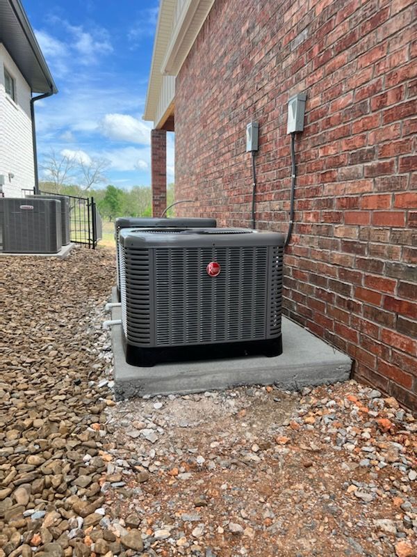 A man in a hard hat is working on an air conditioner.