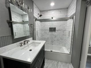 Modern bathroom with white tiled shower, vanity sink, and large mirror