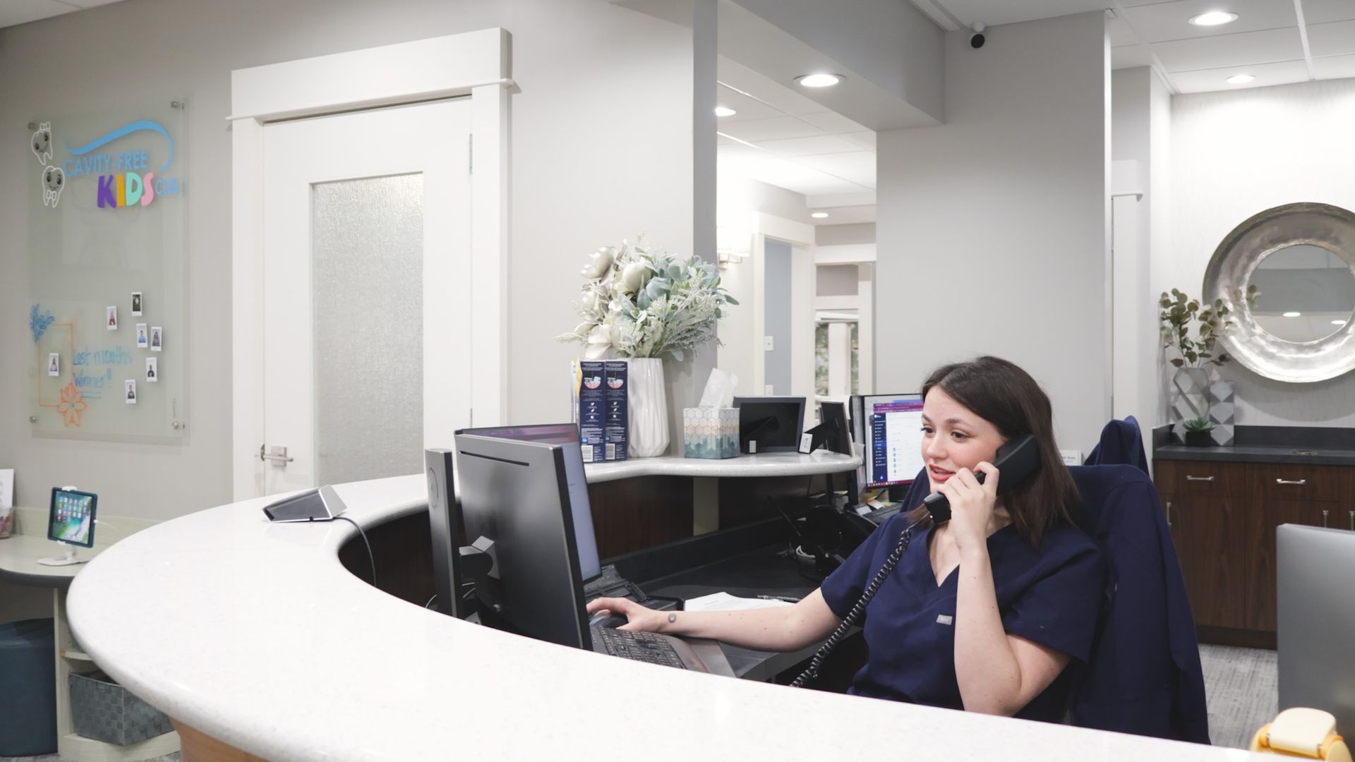 Woman in dentist chair holding cheek coming in for a dental emergency appointment at McMahon Dental.