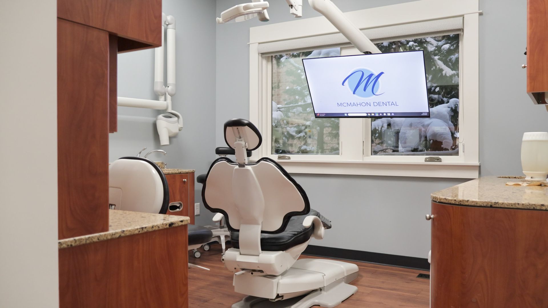Teen at dentist's appointment, mouth open. Dr. McMahon using instruments, wearing black gloves.