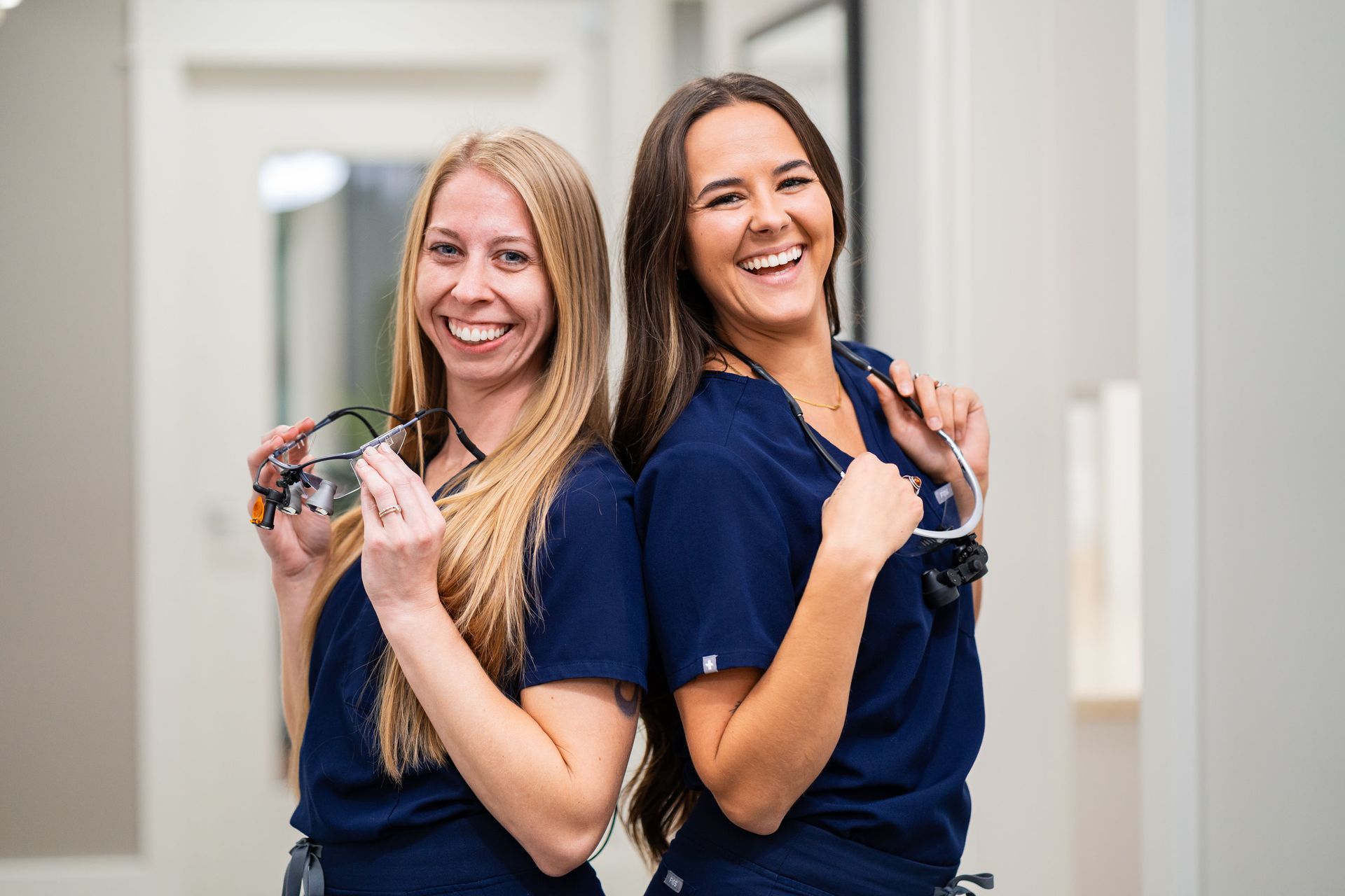 Man in dentist chair with mouth open, receiving teeth whitening treatment under a blue light.