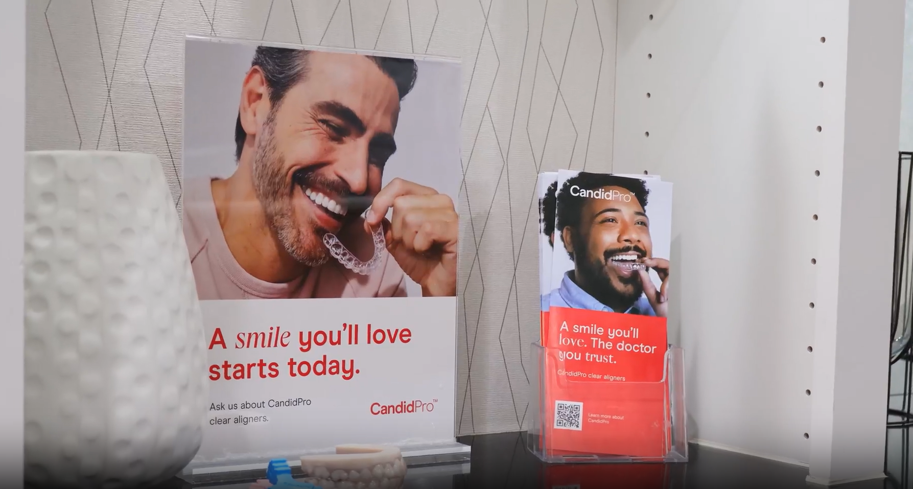 Woman holding CandidPro™ clear aligners, smiling, outdoors.