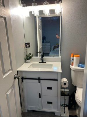 A bathroom with a sink , toilet and mirror.