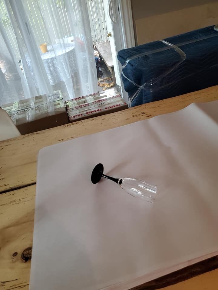 Un verre à vin est posé sur un morceau de papier sur une table en bois.