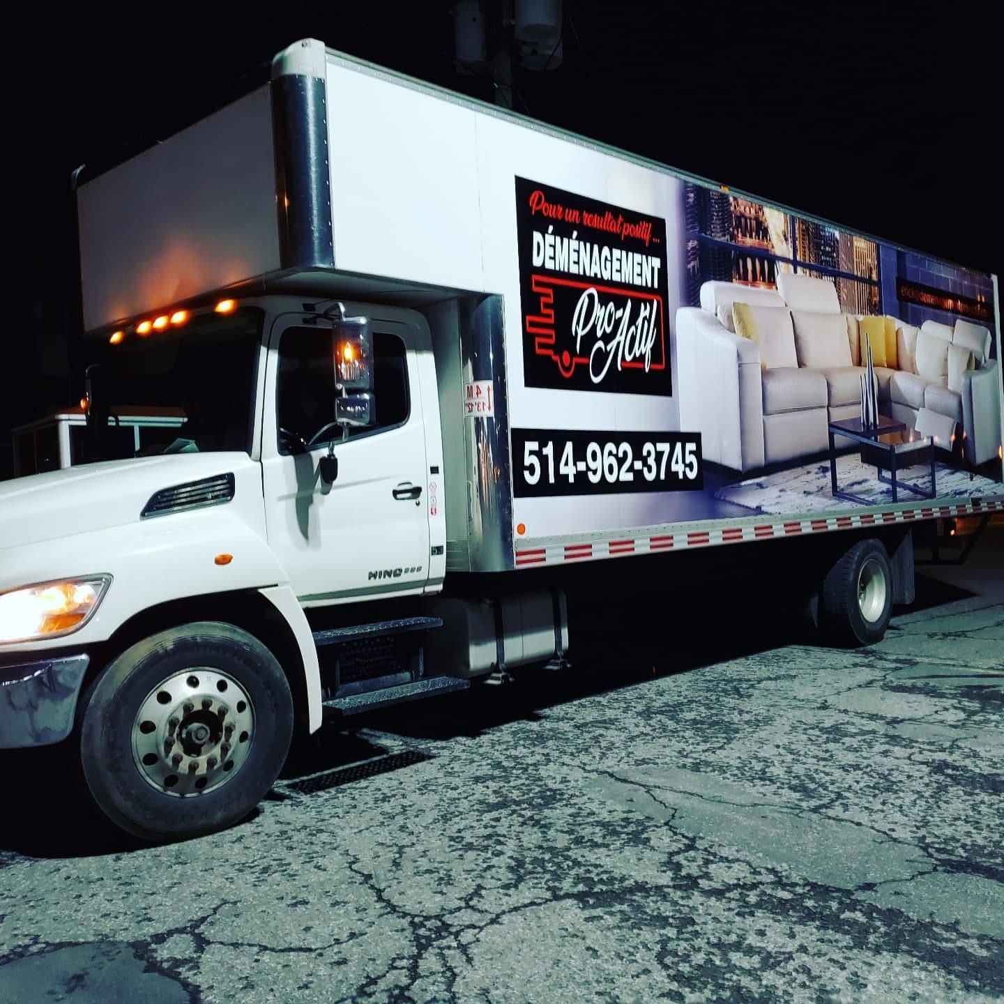 Un camion blanc est garé sur le bord de la route la nuit