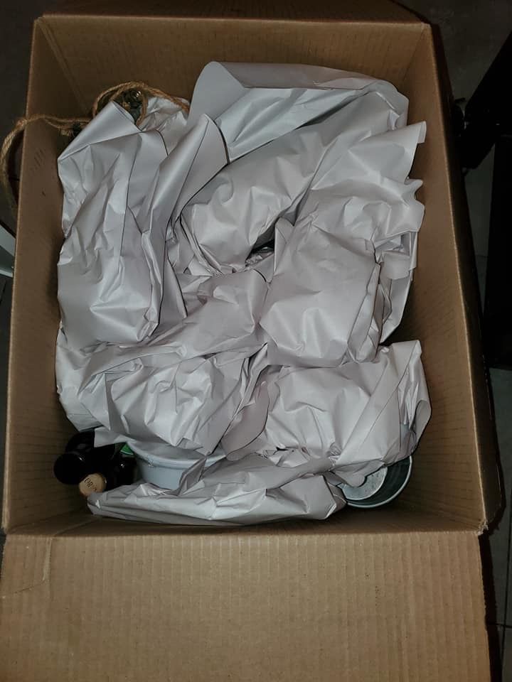 Une boîte en carton remplie de papier d'emballage et de bouteilles.