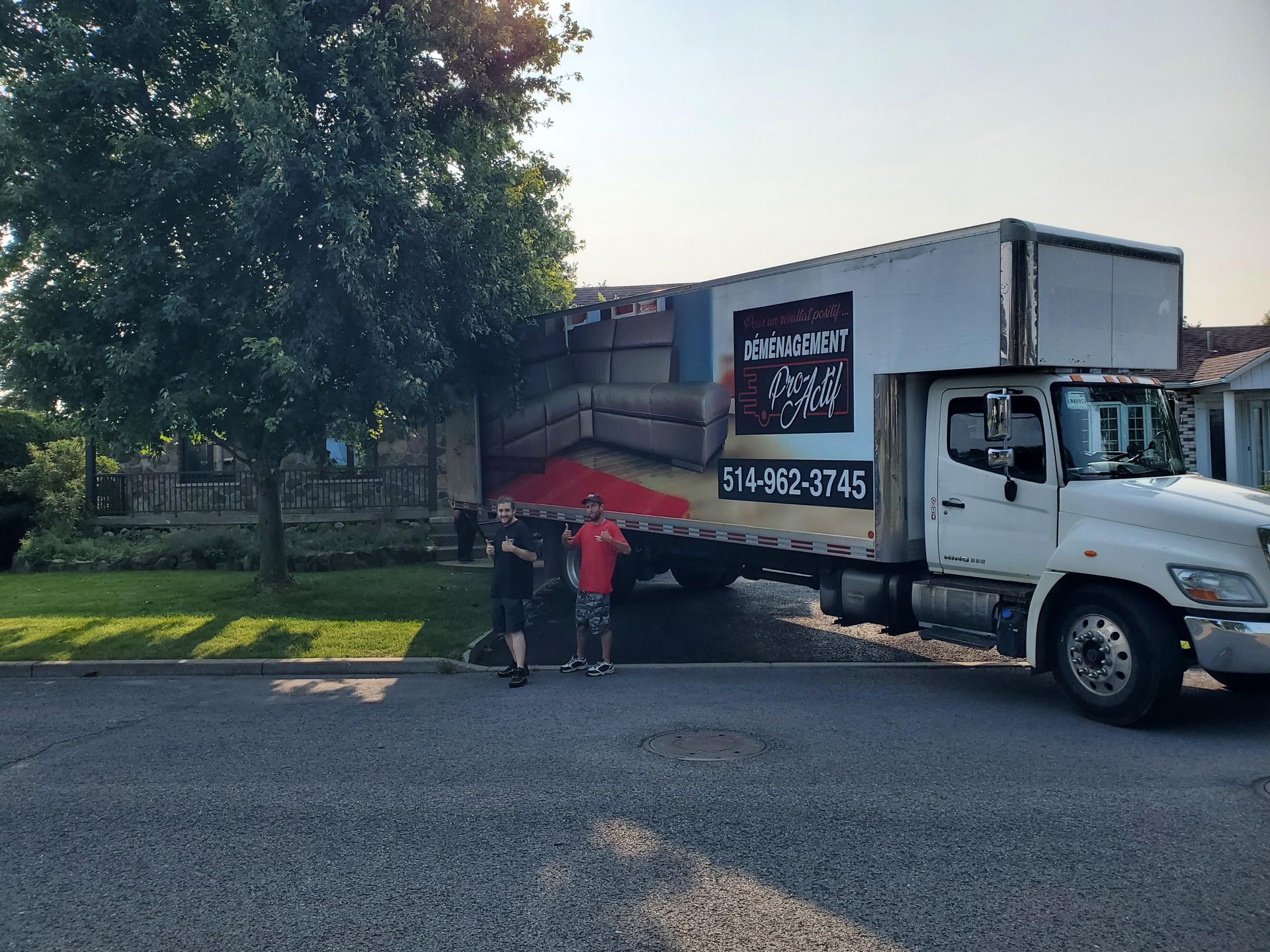 Un camion de déménagement blanc est garé devant une maison.