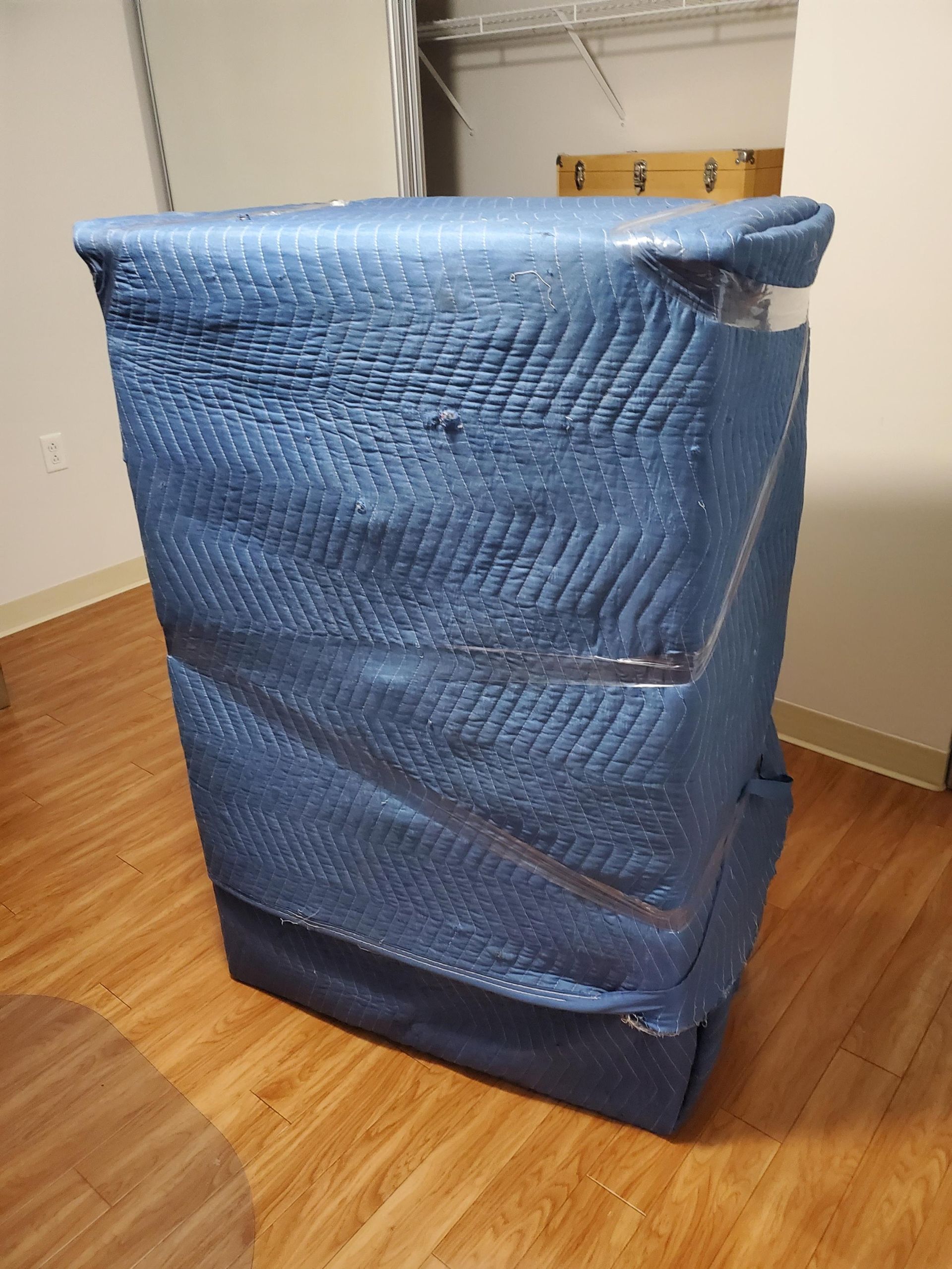 Une couverture bleue est enroulée autour d'une boîte sur un plancher en bois.