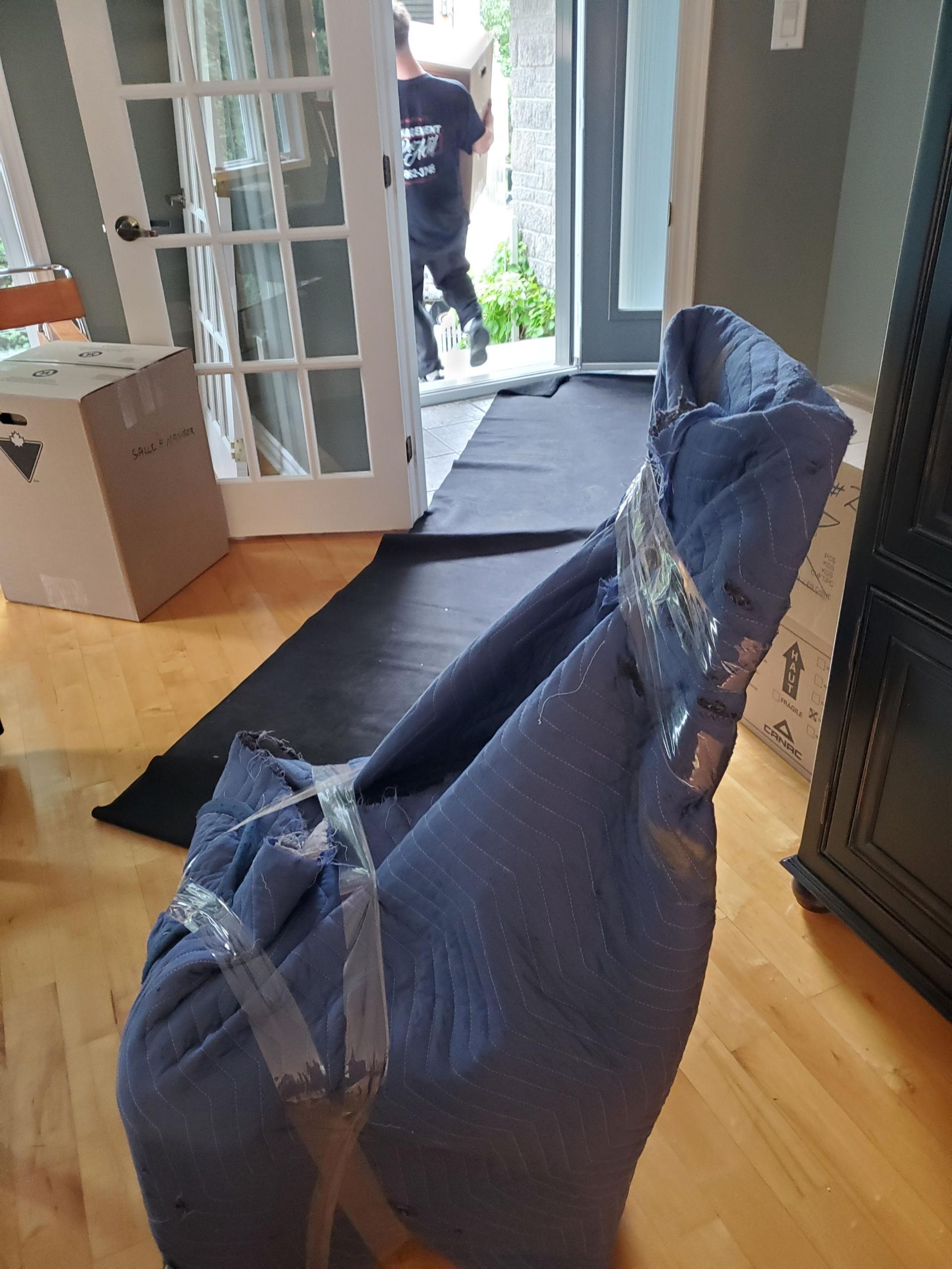 Une chaise est enveloppée de plastique et de ruban adhésif dans un salon.