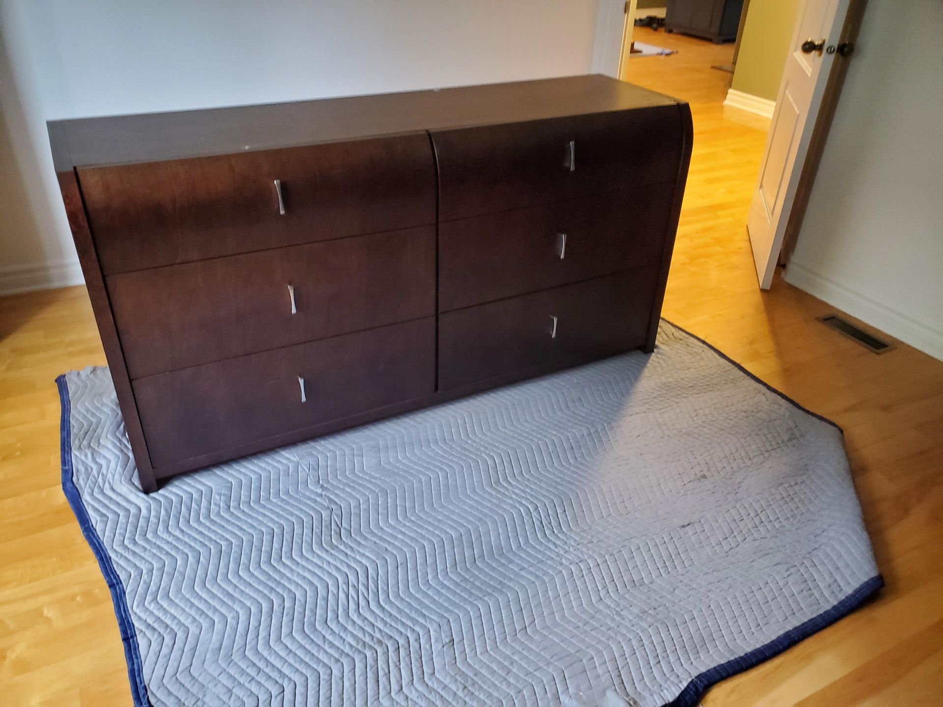 Une commode est posée sur un tapis dans une pièce.