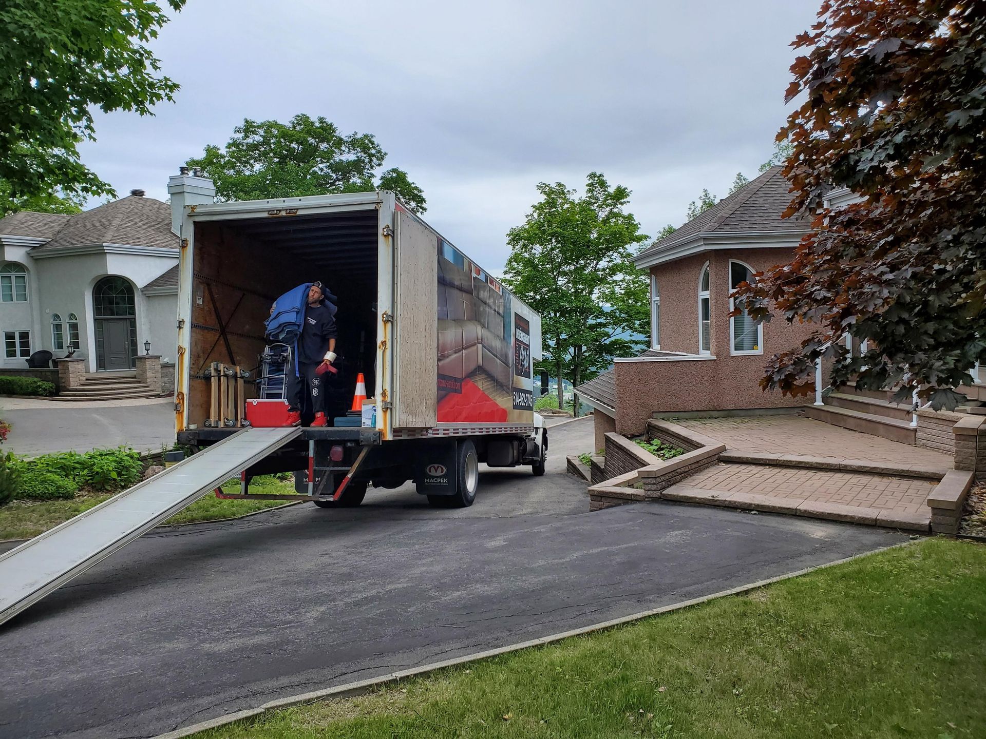 Un camion de déménagement est garé dans une allée à côté d'une maison.