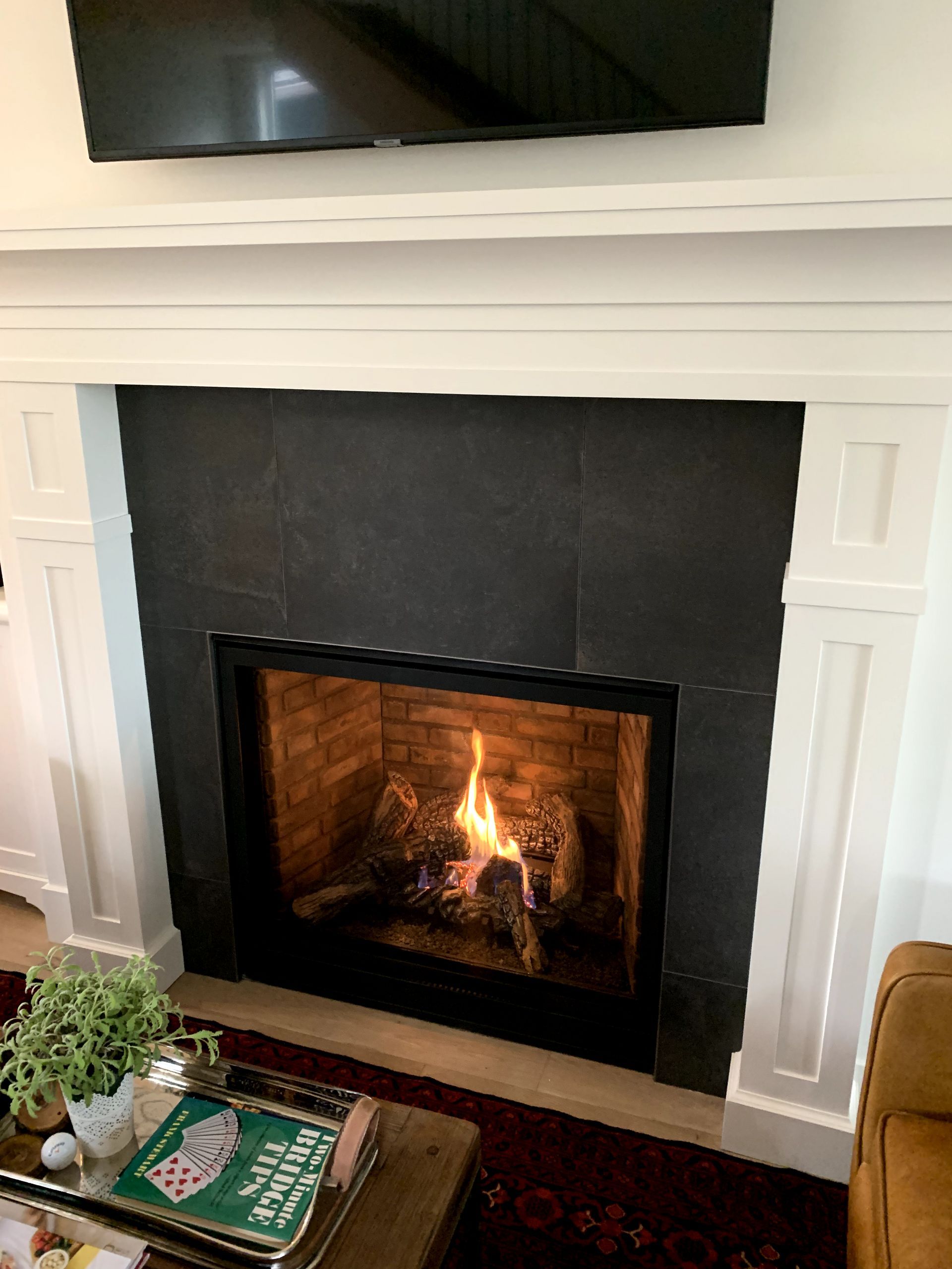 A living room with a fireplace and a flat screen tv.