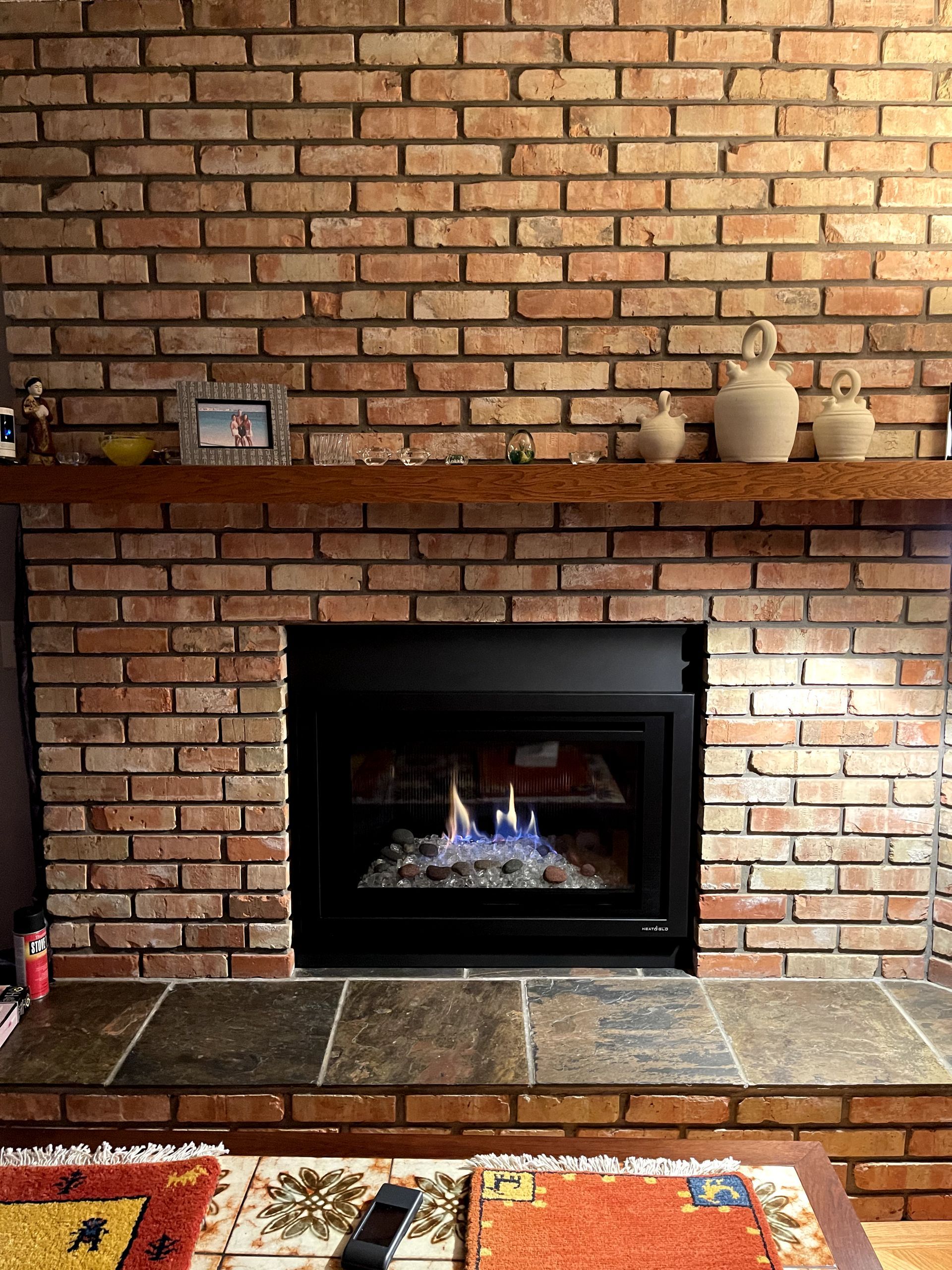 A fireplace in a living room with a brick wall