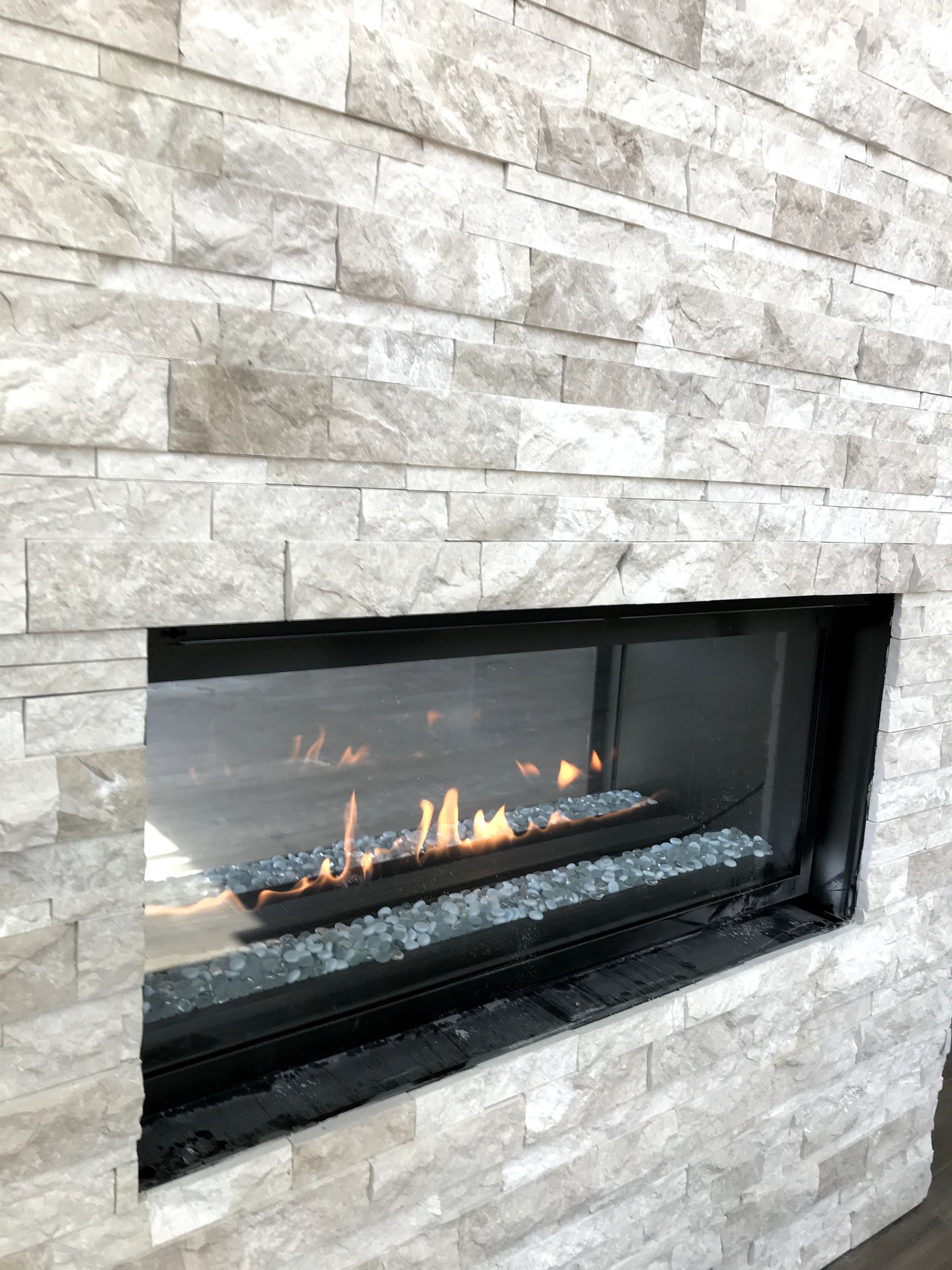 A fireplace is built into a brick wall in a living room.