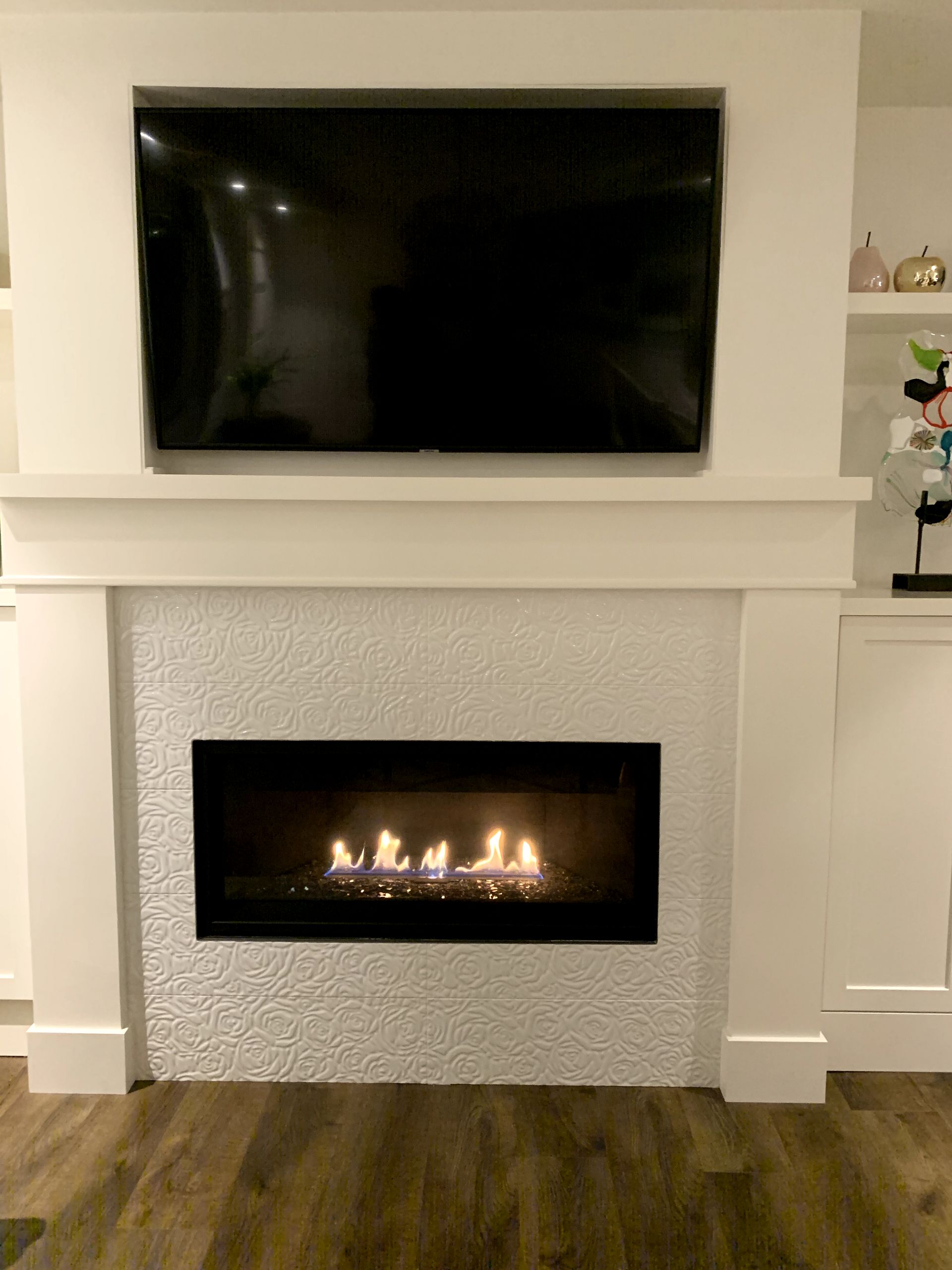A fireplace with a flat screen tv above it in a living room.