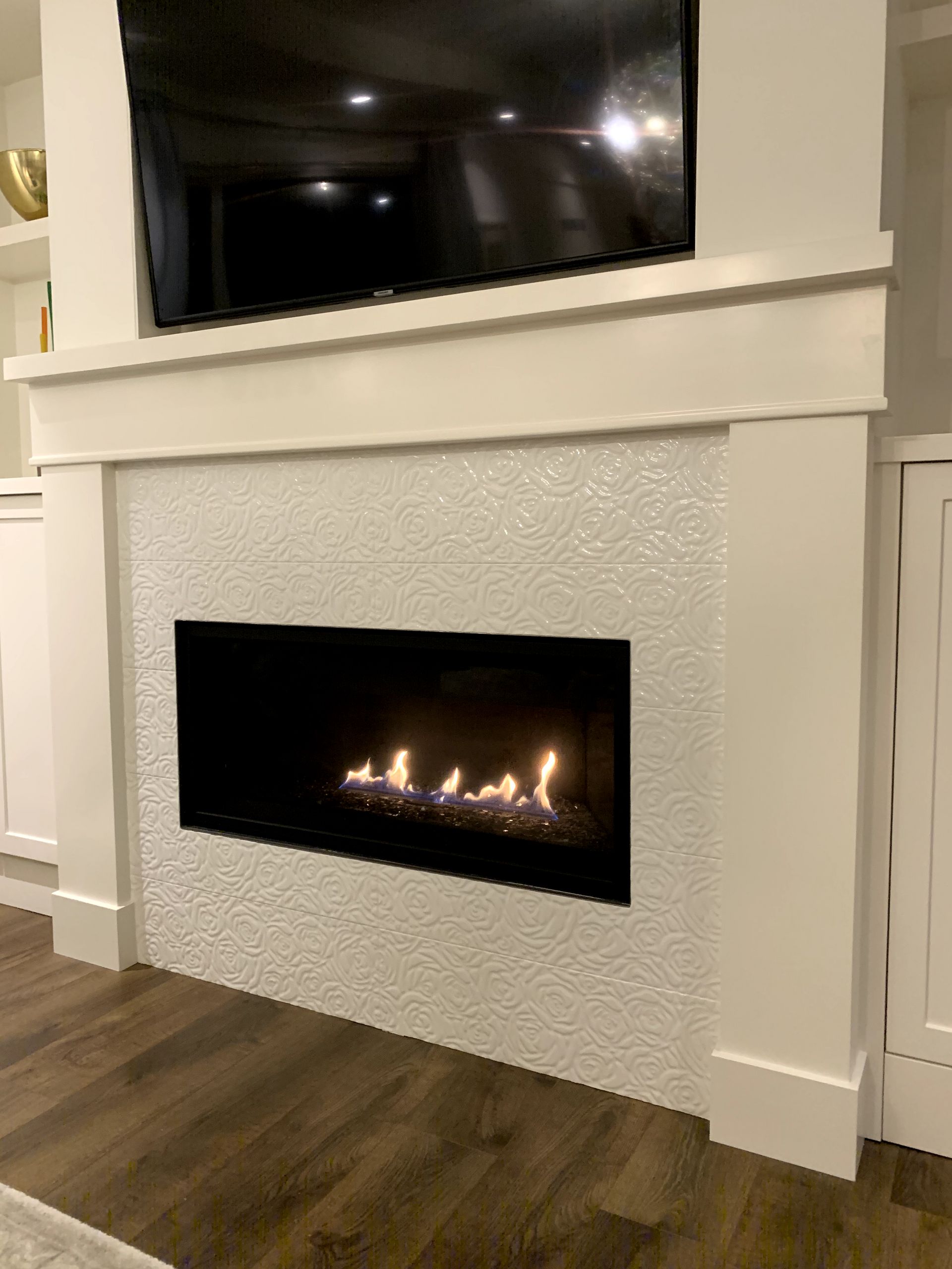 A fireplace with a flat screen tv above it in a living room.