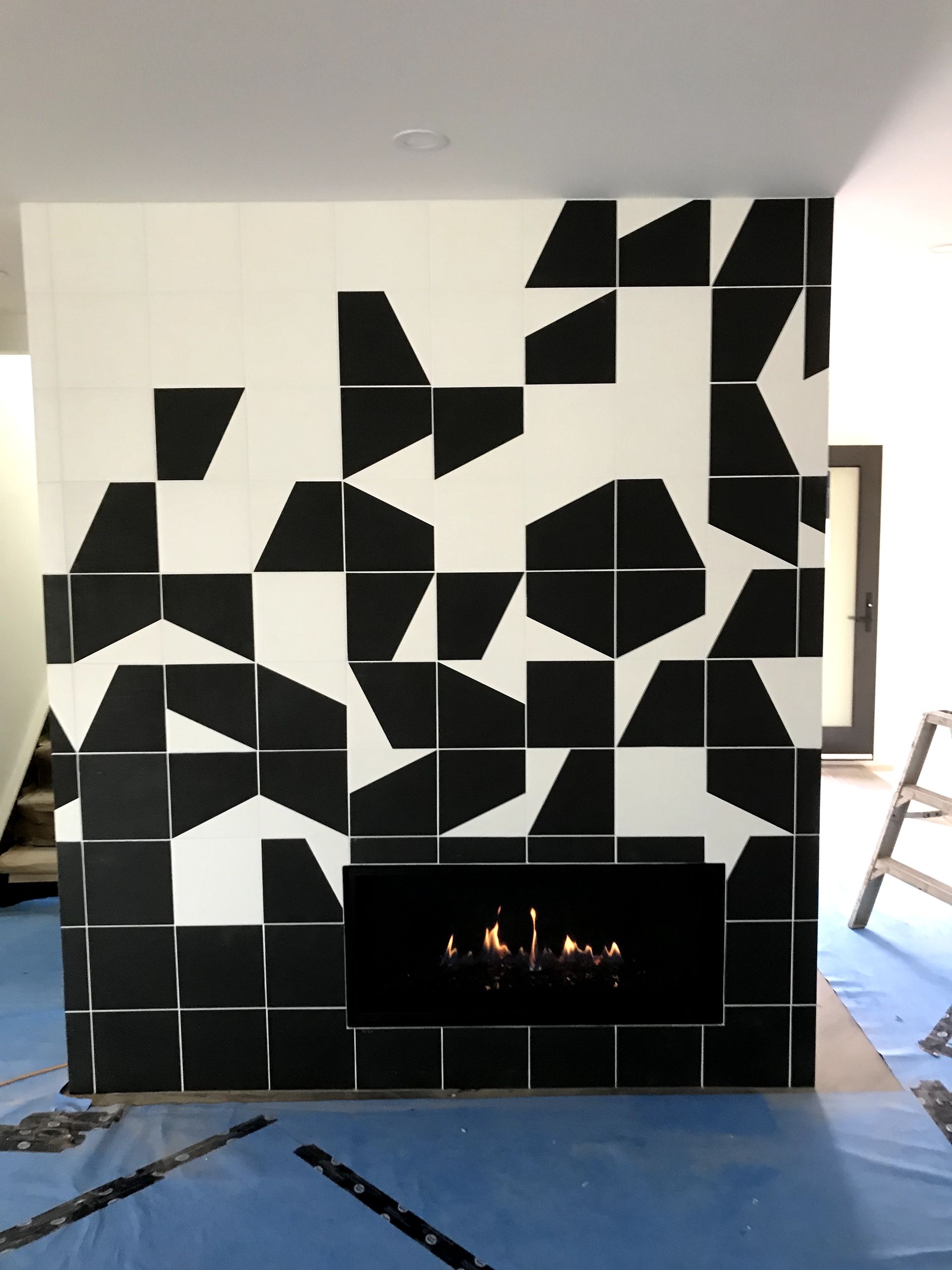 A fireplace with black and white tiles on the wall