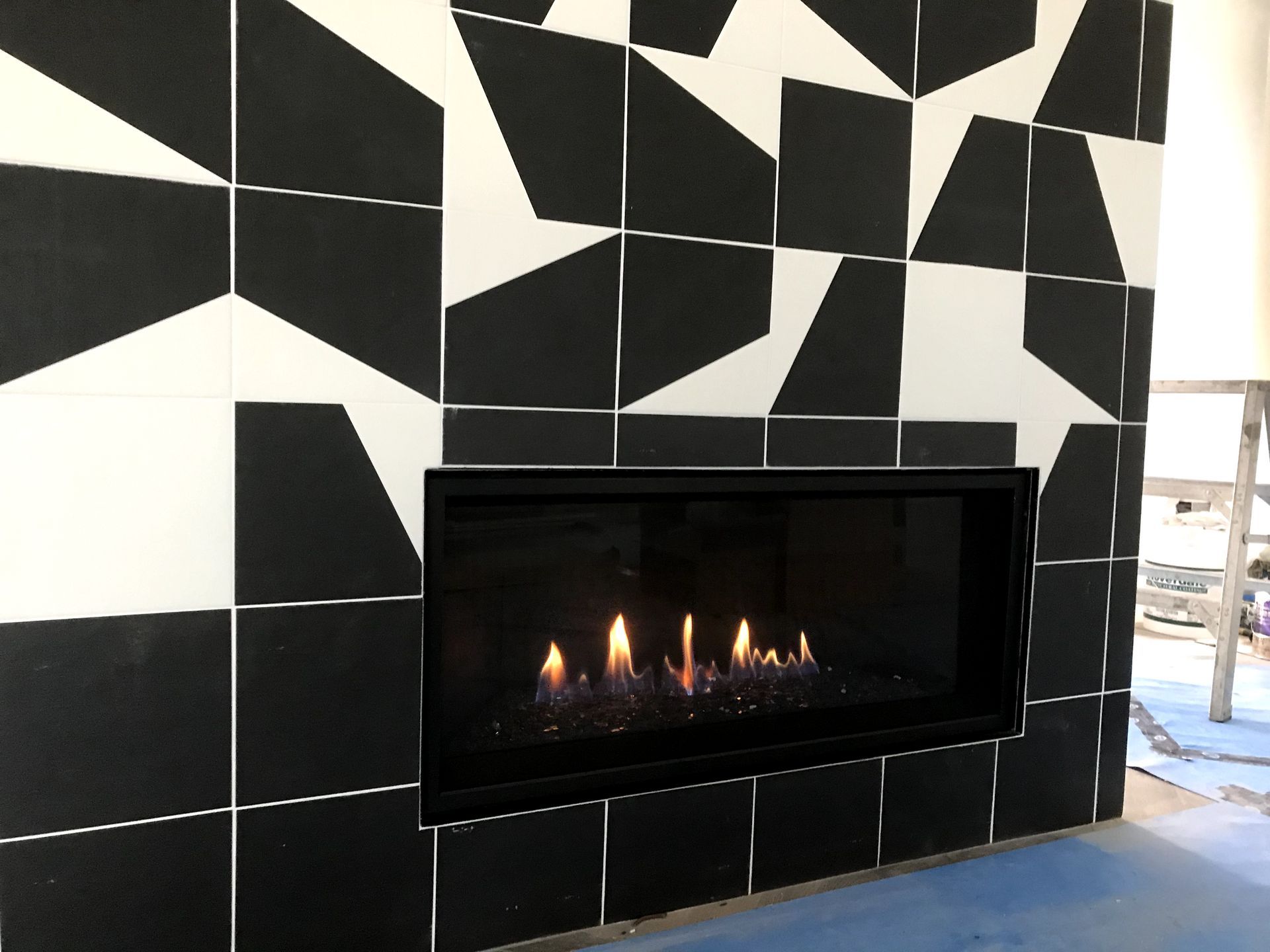 A fireplace with black and white tiles on the wall