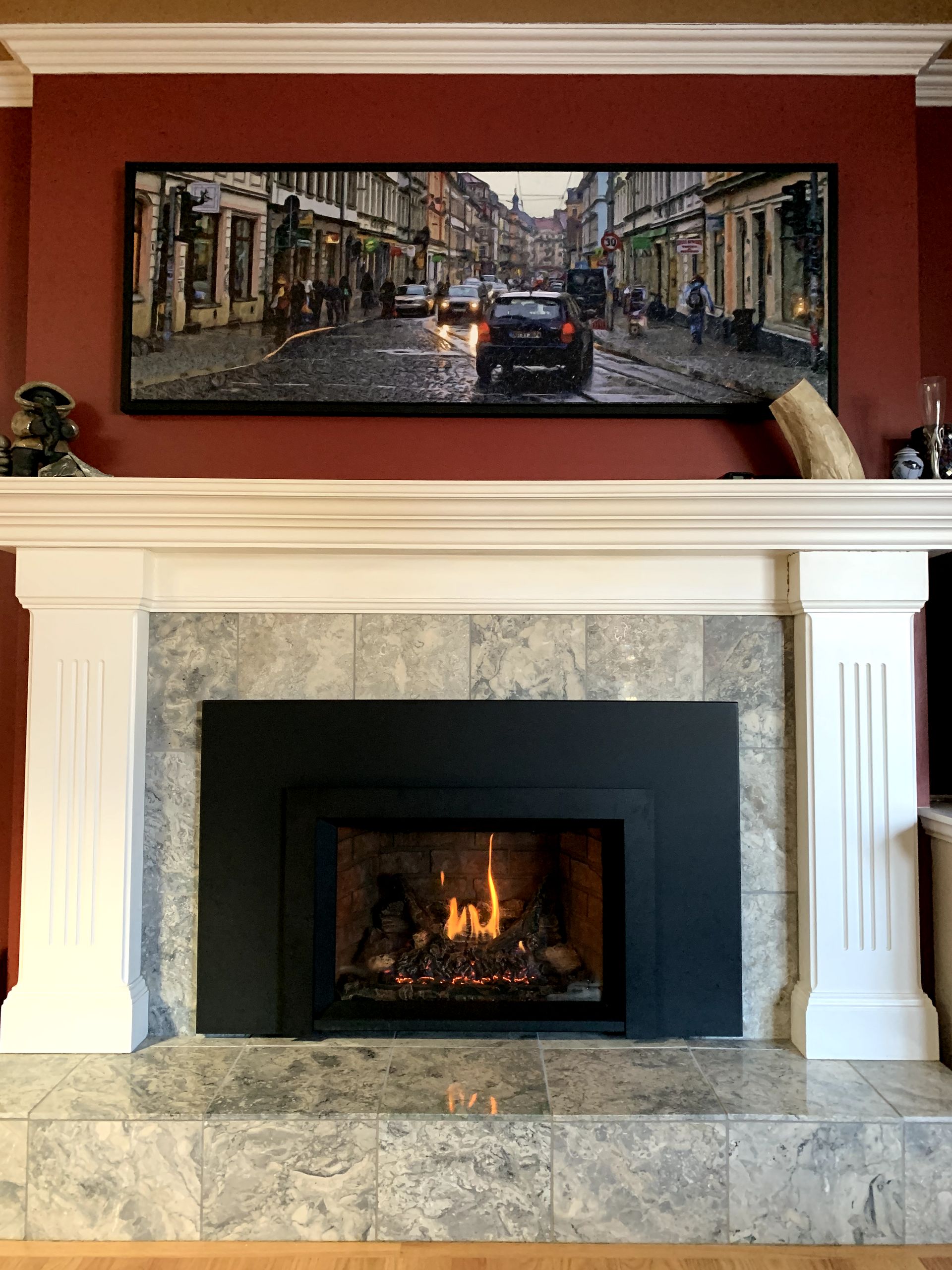 A fireplace with a picture on the wall above it