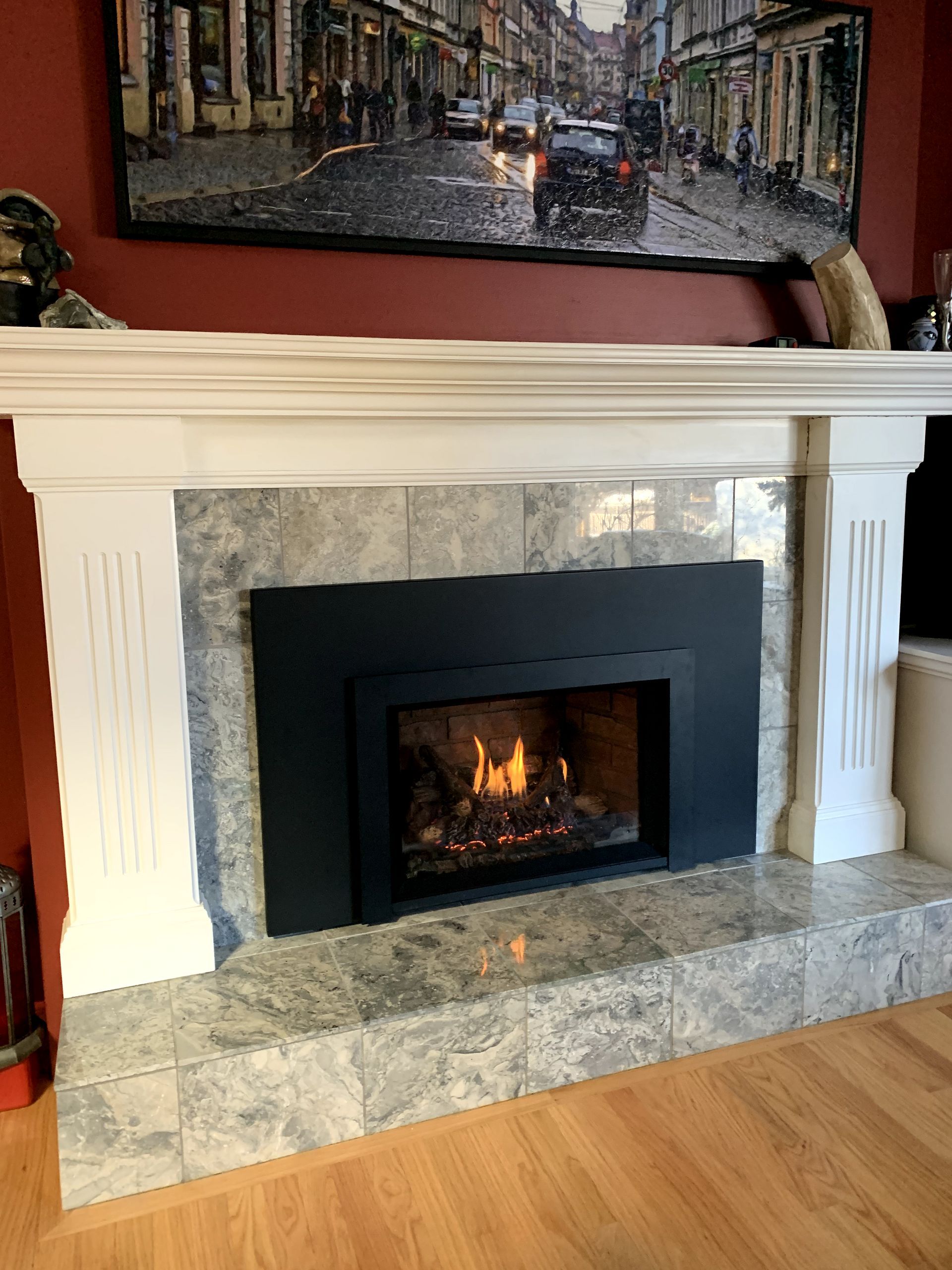 A living room with a fireplace and a picture on the wall.