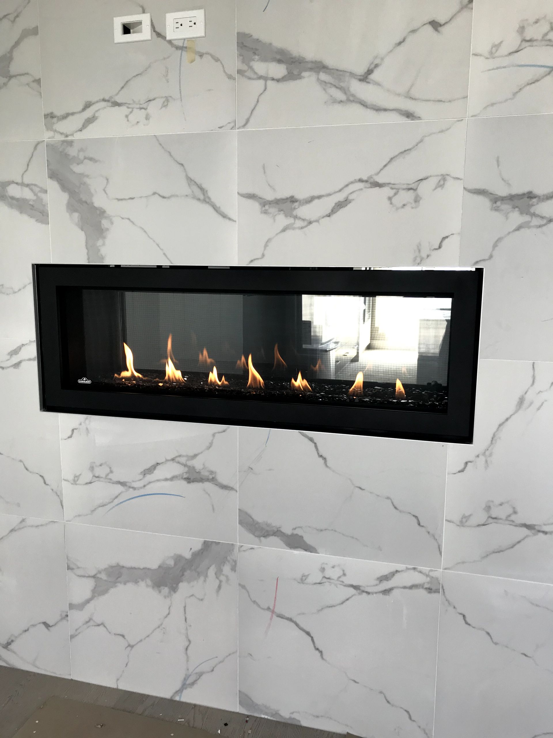 A fireplace is built into a marble wall.