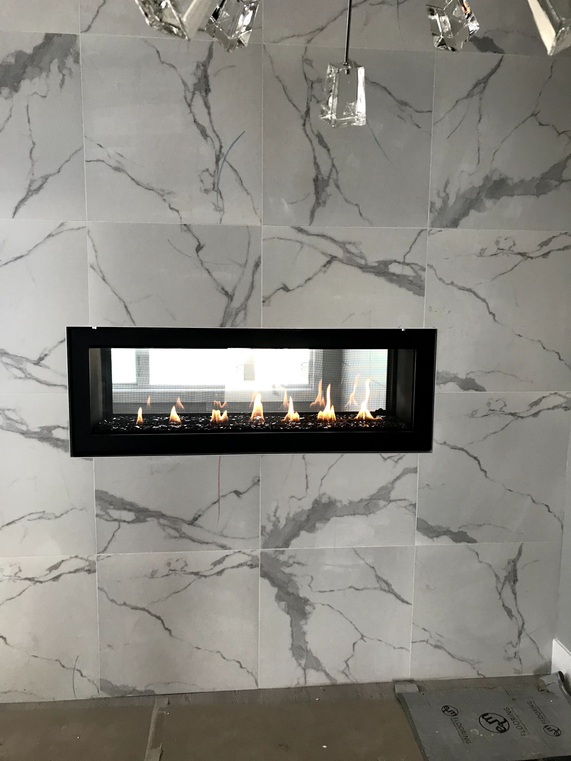 A fireplace is built into a marble wall.