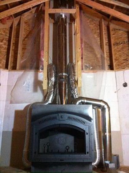 A fireplace is built into the wall of a house under construction.