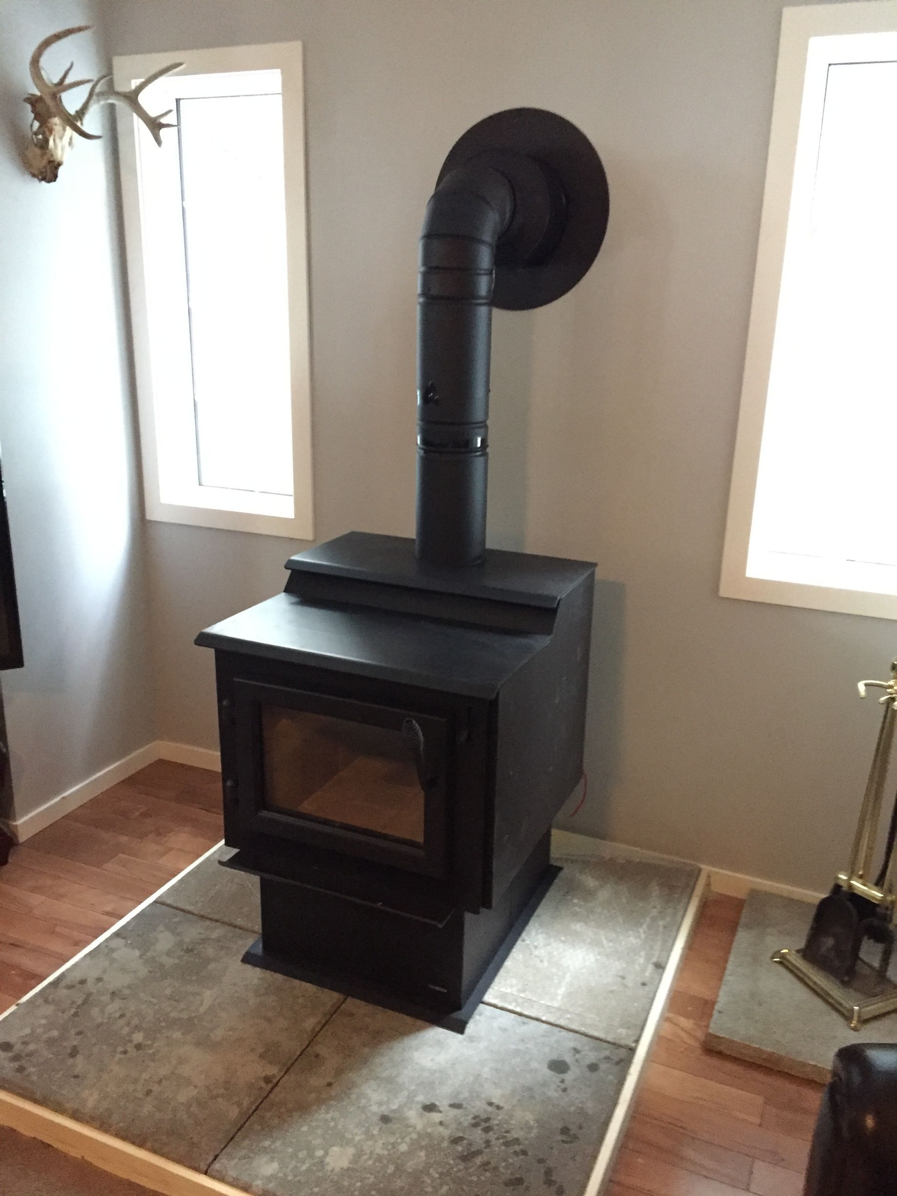 A wood stove is sitting on a tiled floor in a living room.