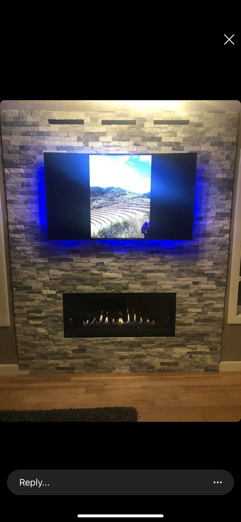 A living room with a fireplace and a flat screen tv mounted on the wall.