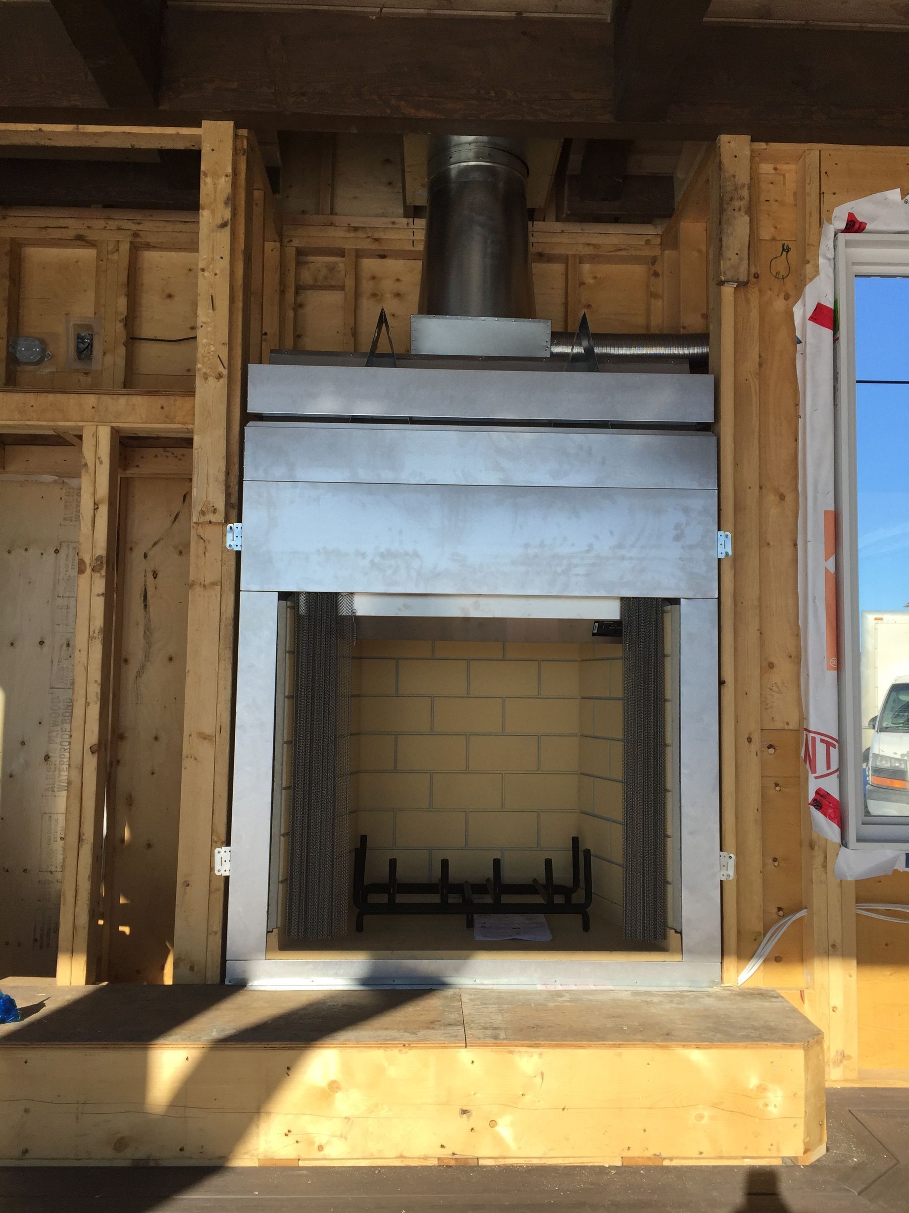 A fireplace is being built into a wooden wall